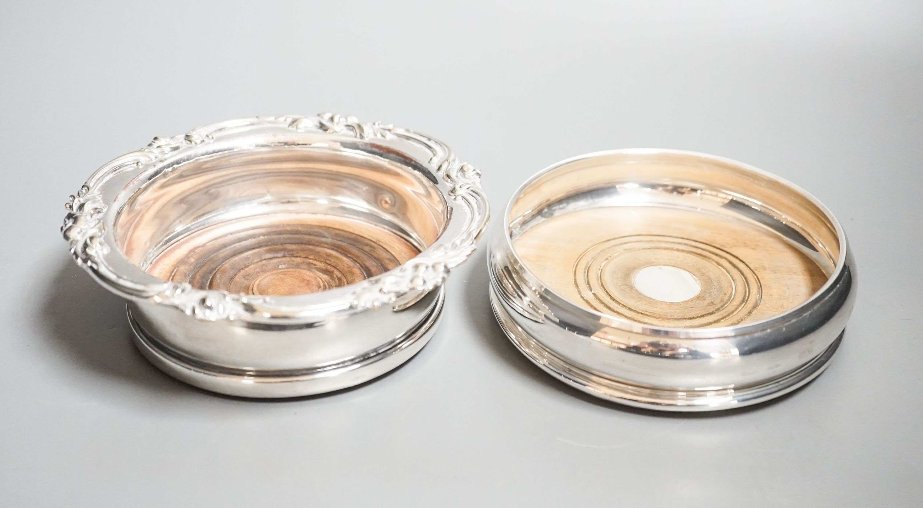 A modern silver mounted wine coaster, 12.2cm and a silver plated wine coaster.